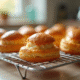 Choux pâtisserie fraîchement cuits sur un grille en cuisine lumineuse