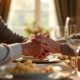 Couple agee tenant la main lors d'un diner d'anniversaire